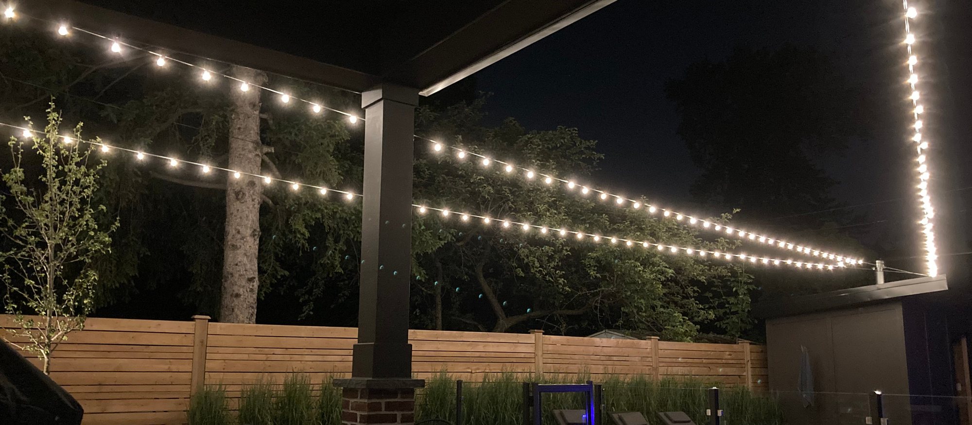 Landscaped patio at night with string lighting